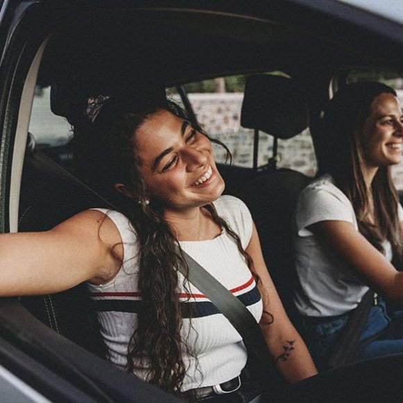 2 vrolijke jonge vrouwen in de auto