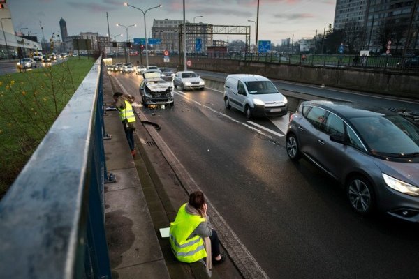 bestuurder met auotpech op pechstrook in fluohesje