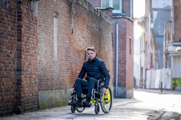 man in rolstoel op het voetpad