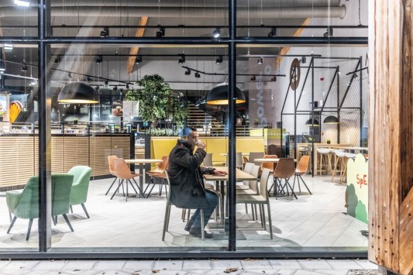 man in tankstation koffie aan het drinken