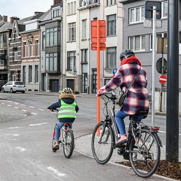 kind dat voor ouder fietst op een fietspad