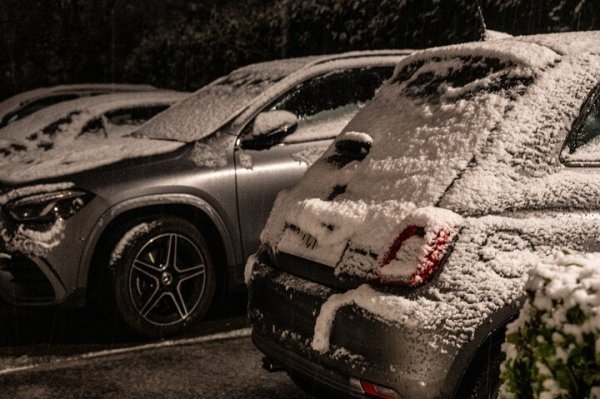 besneeuwde geparkeerde auto's in het donker