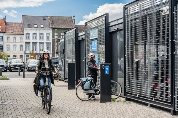 fietser aan ingang afgesloten fietsenstalling station