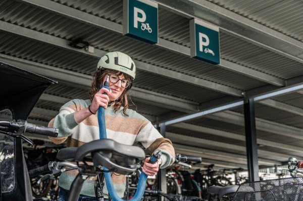vrouw die fiets op slot legt