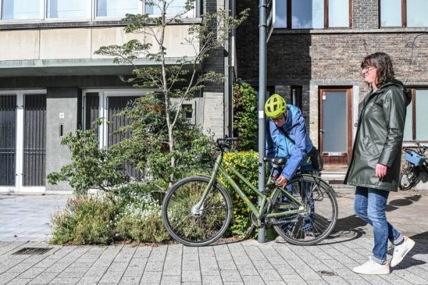Man die fiets op het voetpad vastlegt aan een verlichtingspaal