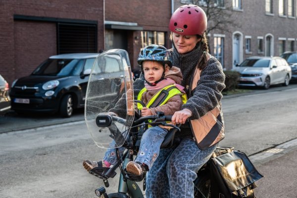 vrouw fietst met kind in fietsstoel vooraan