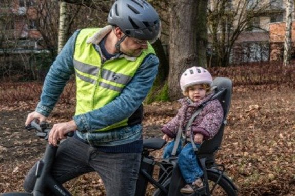 kind achteraan op fiets in een fietsstoeltje
