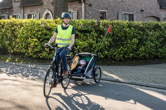 man die fietst met een fietskar