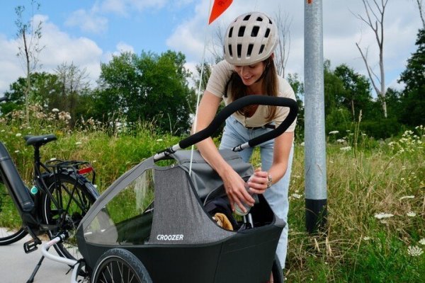 moeder die bagage wegstopt in een fietskar