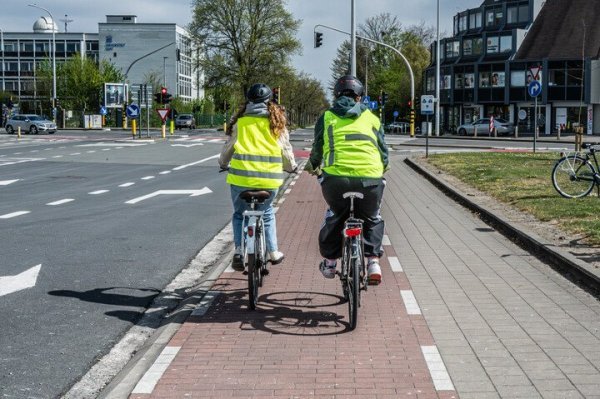 2 fietsers op een fietspad met wegmarkeringen
