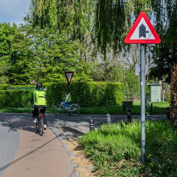fietser op kruispunt met voorrangsbord en fietssuggestiestrook