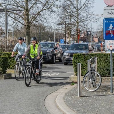 2 fietsers in fietszone met eenrichtingsverkeer, auto achter hen